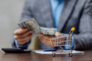 Entrepreneur Counting Near Small Shopping Cart Showing E-Commerce Sales Concept