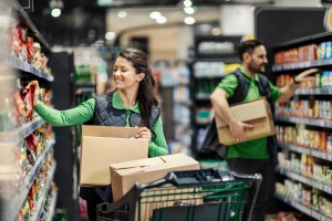 Workers Arranging Groceries on Shelves in A Retail Shop