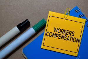 Workers Compensation Written on Sticky Notes on Office Desk