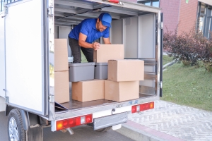 Courier Worker Loading Parcels in Truck for Delivery