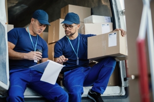 Courier Workers Organizing Delivery with List Using Notepad
