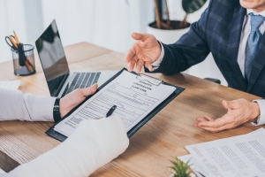 Injured Worker Signing Form for Compensation Claim in Office of Businessman